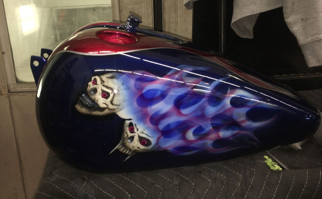 Custom airbrushed skull-and-flame motorcycle tank