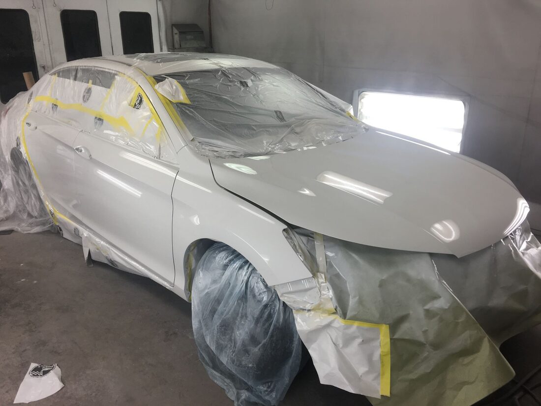 A vehicle masked and prepped for paint and refinishing at Just Joe's